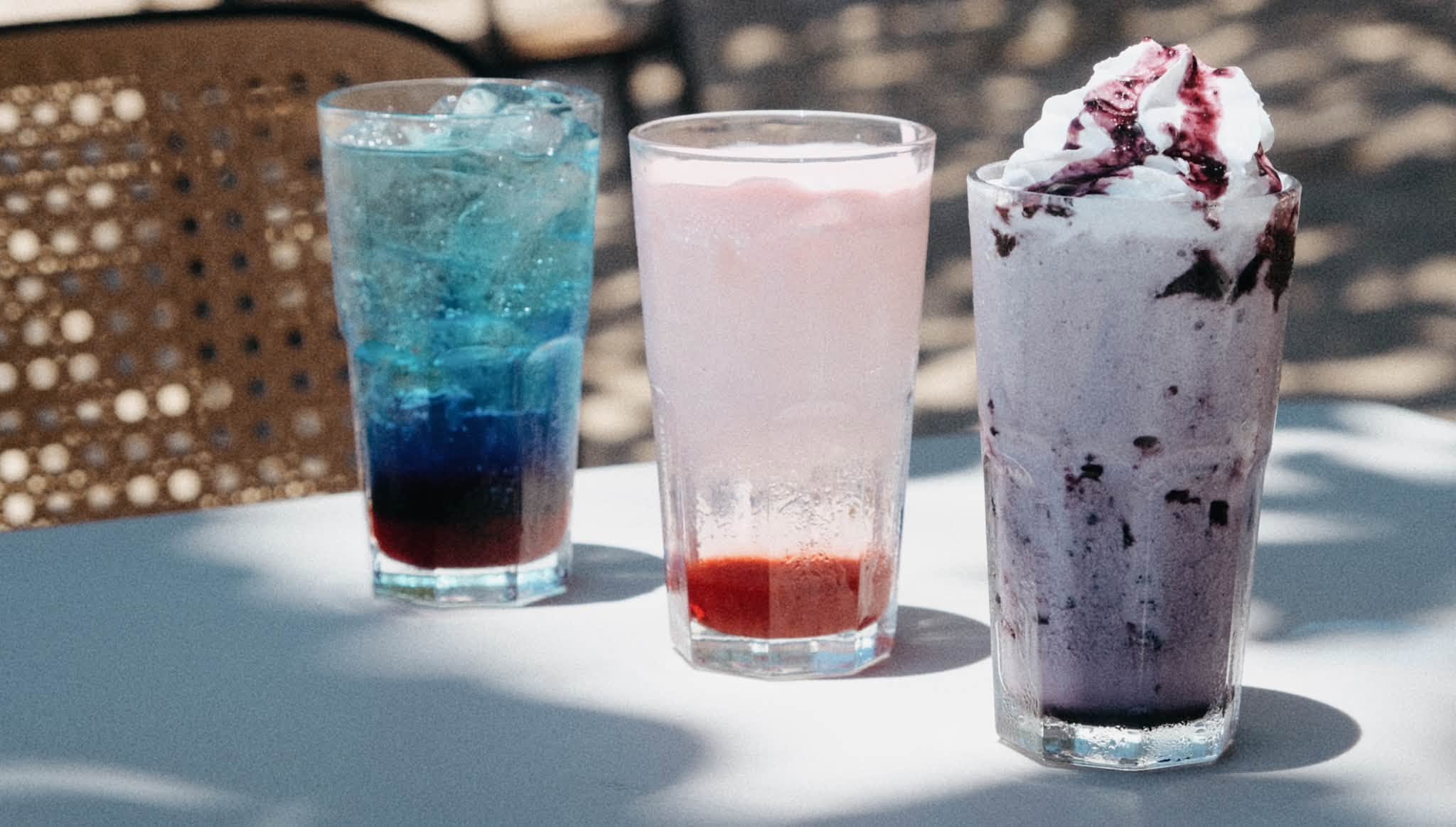 Trio of BAIA iced sodas and blueberry frappes on cafe table