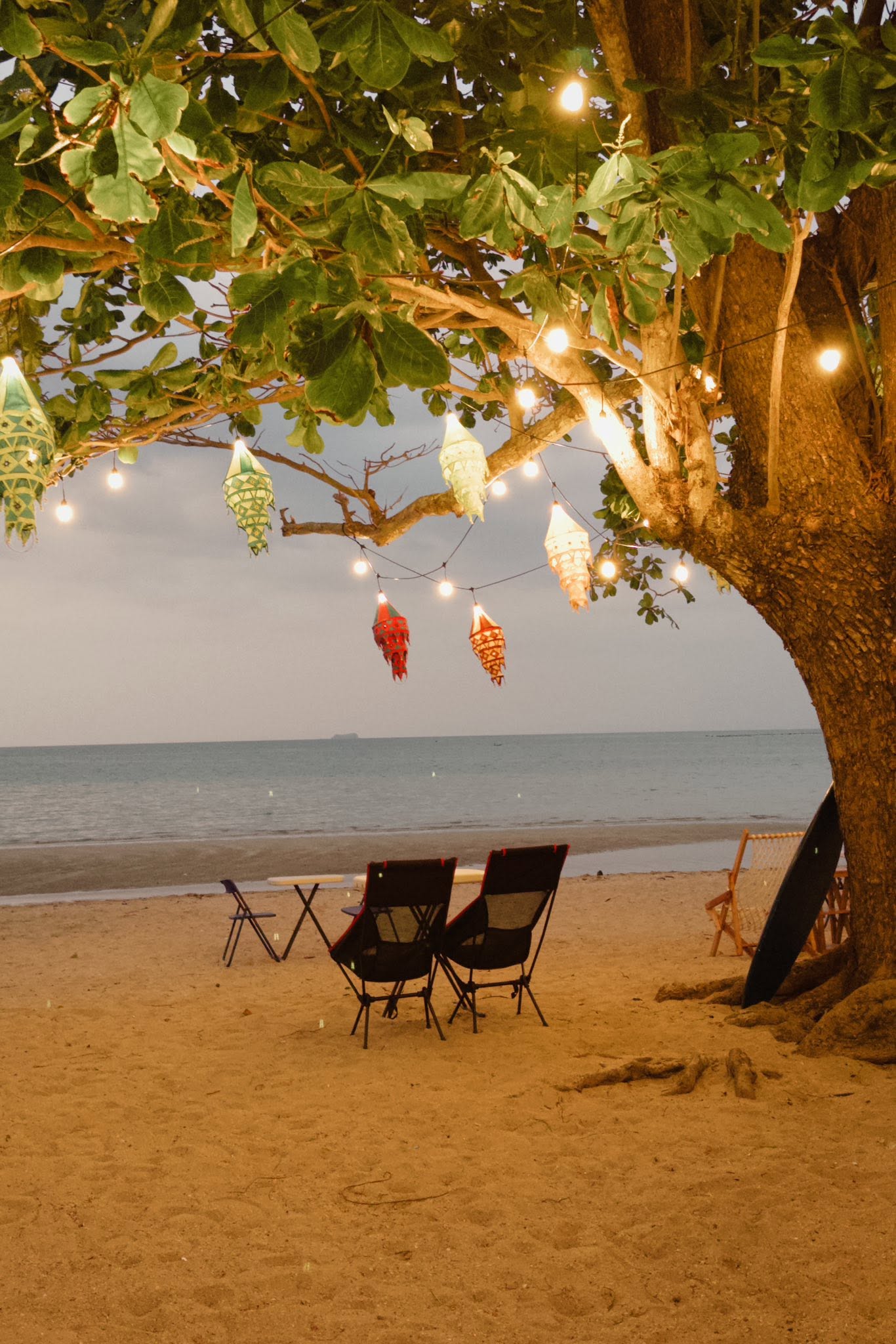 Twilight lanterns on the beach by the waves